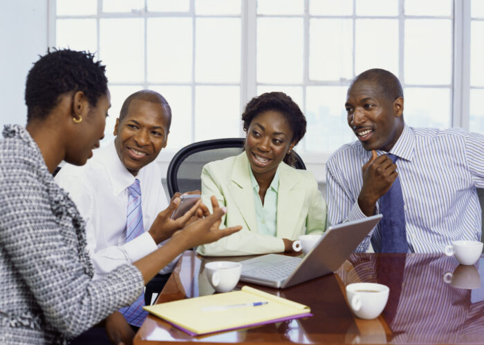 two businessmen and two businesswomen discussing in an office
