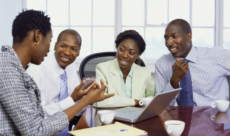 two businessmen and two businesswomen discussing in an office